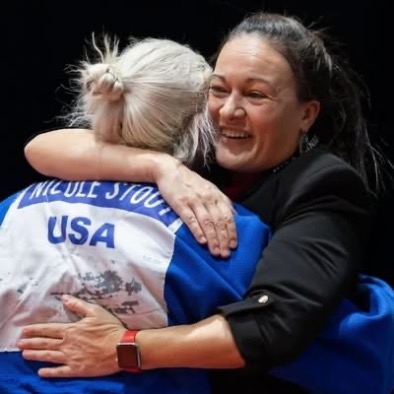 Sensei Carrie Chandler hugging an athlete wearing USA judo gear after a competition