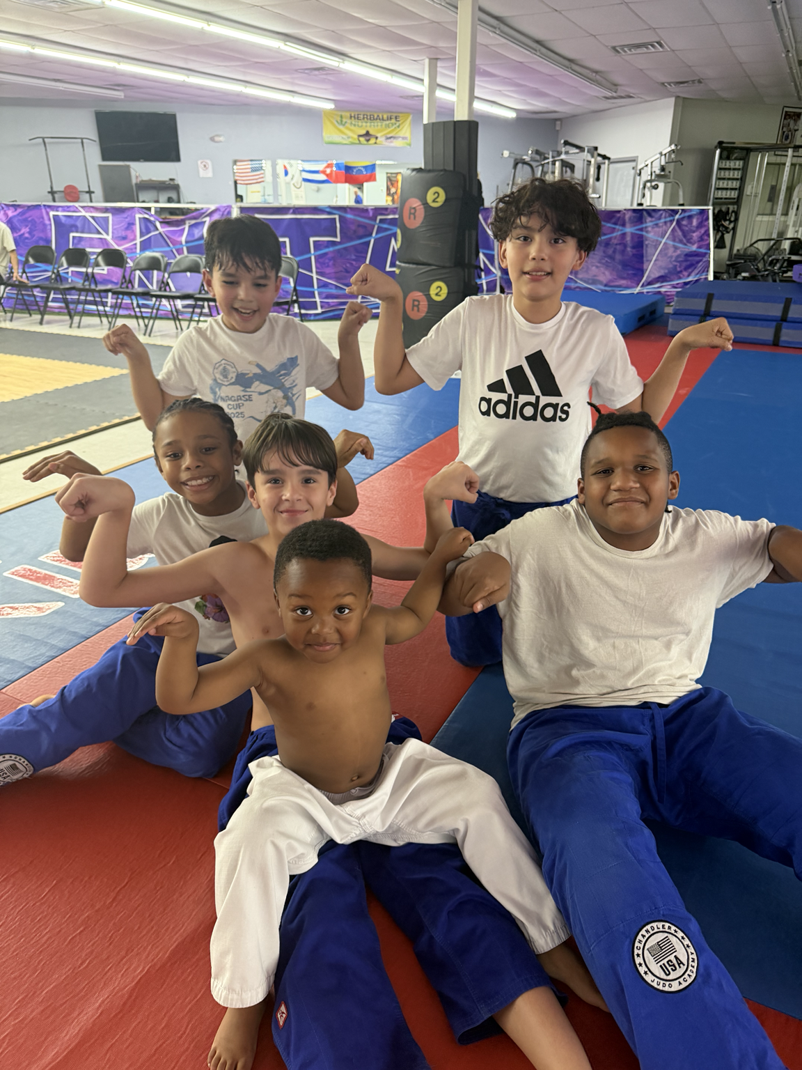 Kids flexing and smiling on the judo mat — showing confidence and fun at Chandler Judo Academy